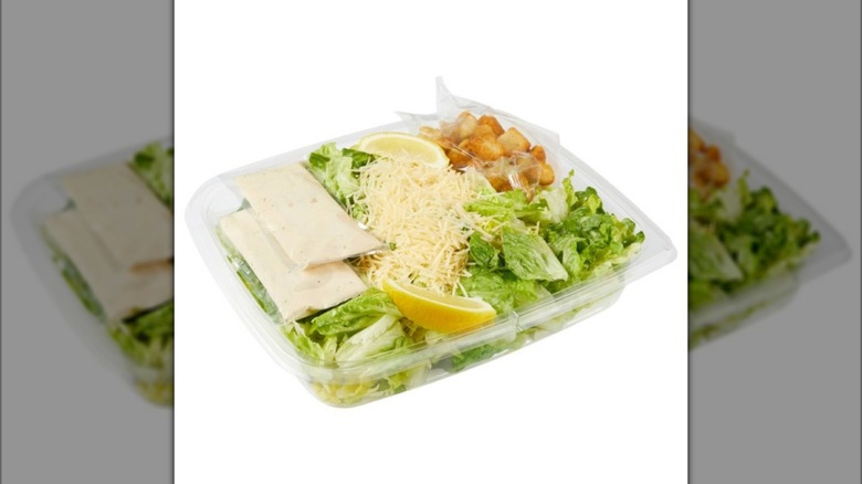 The Kirkland Signature Caesar Salad with Caesar Dressing & Croutons from Costco on white background