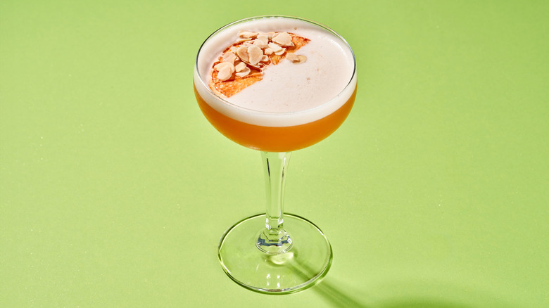 a coupe glass holding a garnished orange cocktail