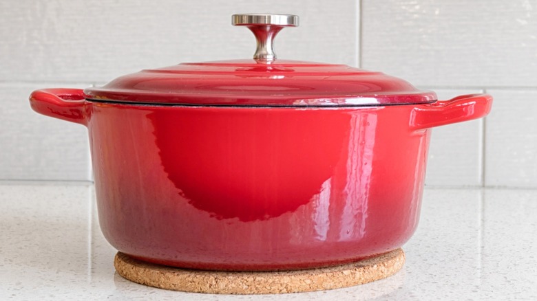 Red Dutch oven sitting on a countertop.
