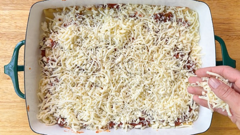 Grated mozzarella cheese layered onto cottage cheese lasagna in 13 x 9-inch pan