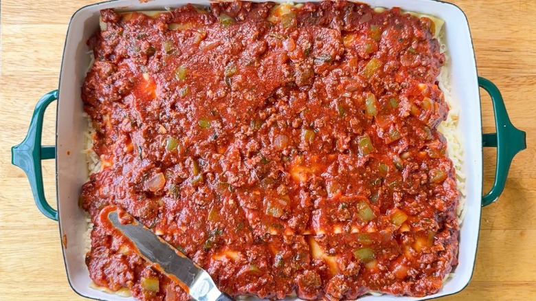 Unbaked cottage cheese lasagna in 13 x 9-inch pan with sauce on top