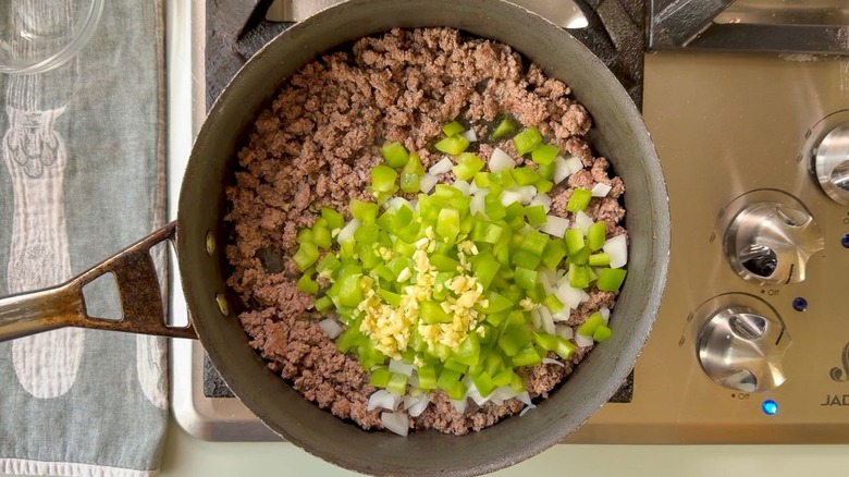 Browned ground beef with chopped green bell pepper, onion, and garlic