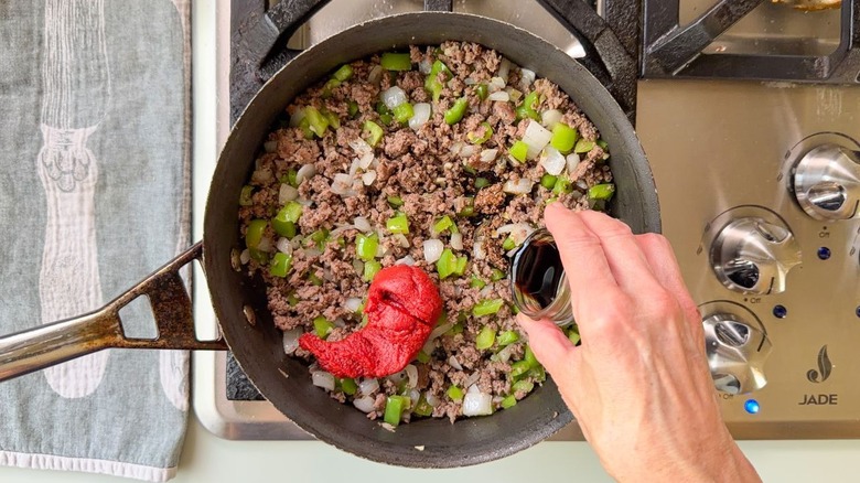 Adding tomato paste and balsamic vinegar to ground beef and aromatic vegetables in skillet on stovetop