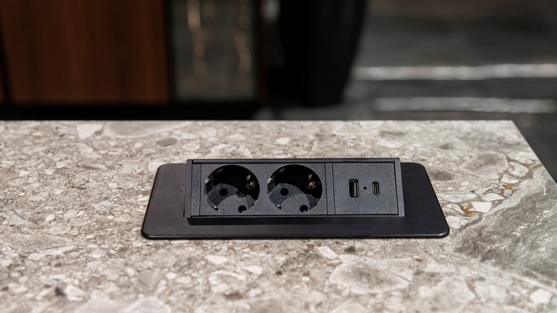 An outlet is built into a marble countertop