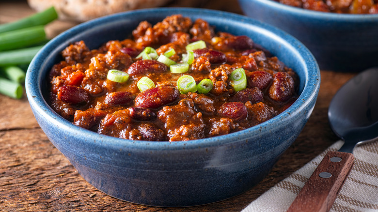 A bowl of chili with spring onions