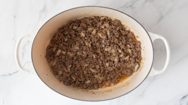 cooked ground beef and onions in a white pot