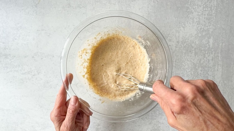 Mixing crab cake filling for egg rolls in glass bowl