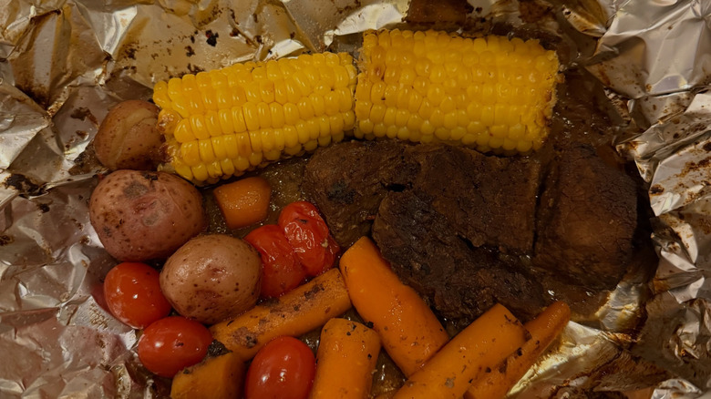 A skillet with shrimp, sausage, and corn