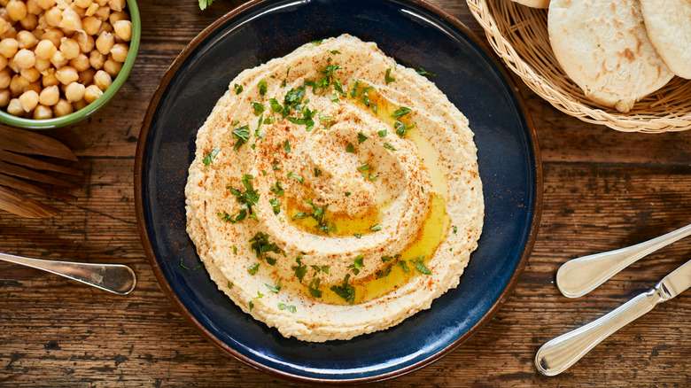 a bowl of homemade hummus with chickpeas and pitas