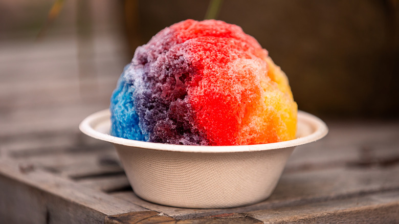 colorful shaved ice in a white paper bowl