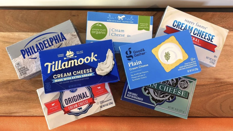 A variety of cream cheeses brands in a pile.