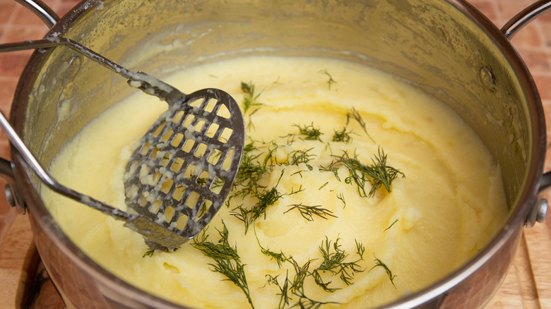 Mashing potatoes in a bowl