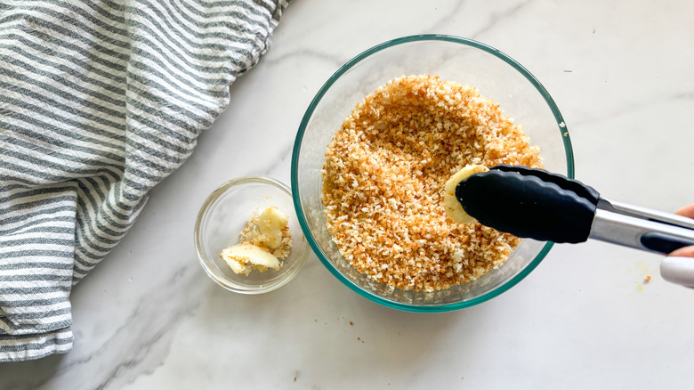 tongs removing garlic from bowl