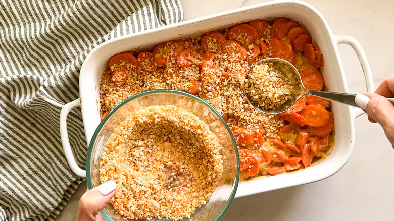 sprinkling breadcrumbs on carrot casserole
