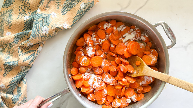 flour on carrots in pan