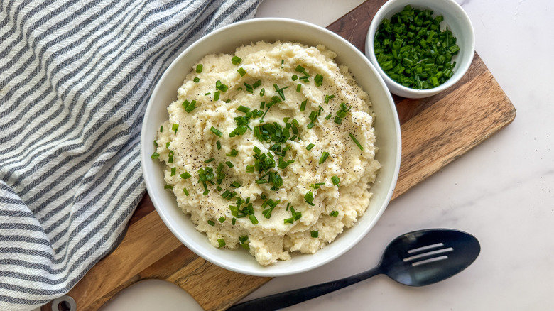 Cauliflower mash in bowl garnished with chives