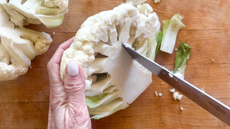 knife cutting core of cauliflower