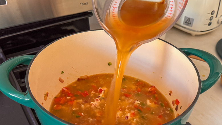 Adding broth to soup