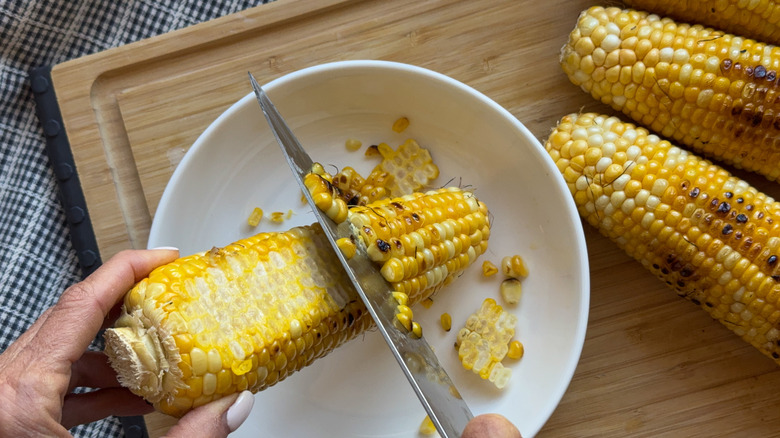 hand cutting kernels off cob