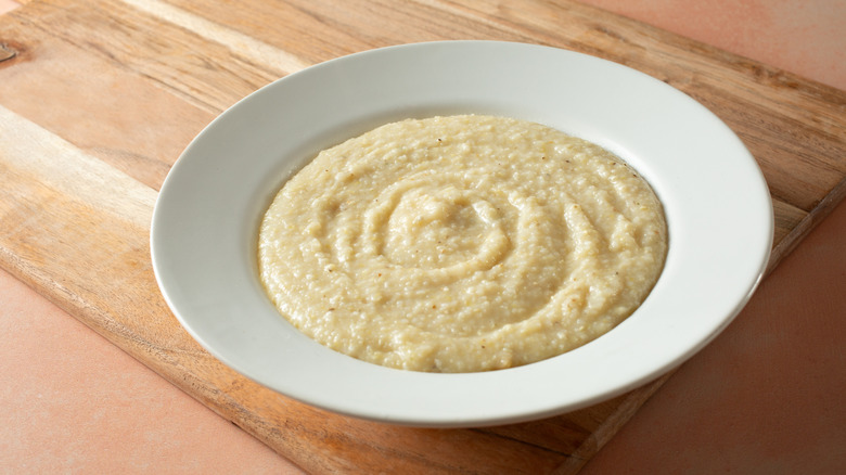 Bowl of grits on a wooden table.