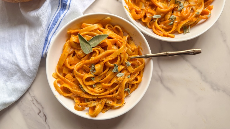 Bowls of pumpkin pasta garnished with sage