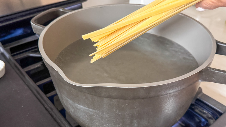 adding pasta to pot