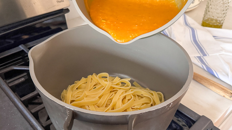 pouring pumpkin sauce into pasta pot