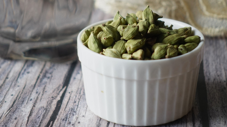 green cardamom pods in a white bowl