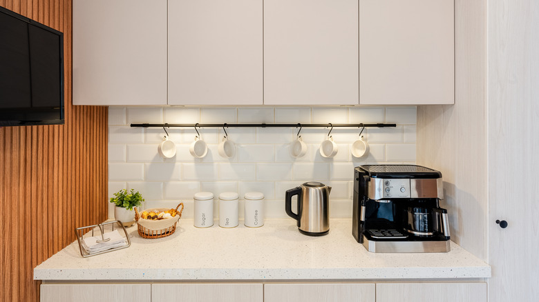 An organized coffee counter in a white kitchen