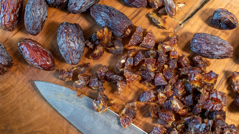 Chopped and whole dates on a cutting board