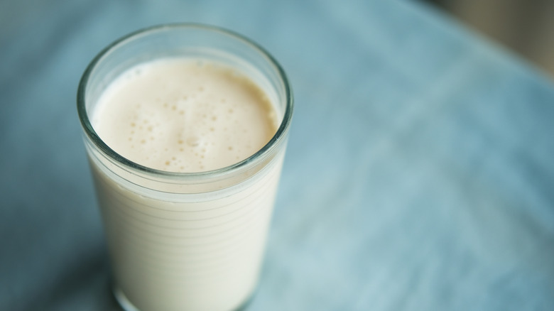 Glass of kefir on blue background