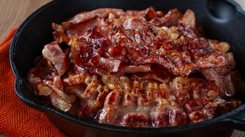 Crispy bacon strips in a cast iron pan