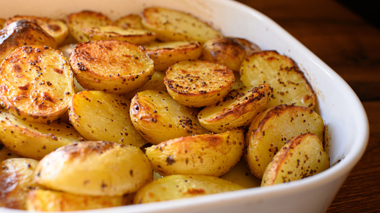 Crispy roasted potato halves in a white baking dish