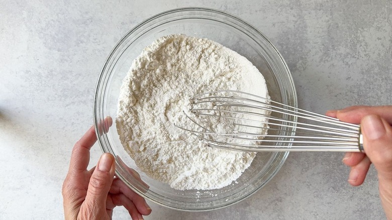 Whisking dry ingredients for beer batter fish in glass bowl
