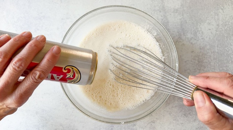 Whisking beer into beer batter for fish