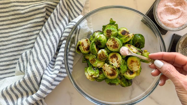hand adding salt to bowl
