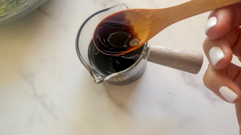 hand holding spoon of glaze