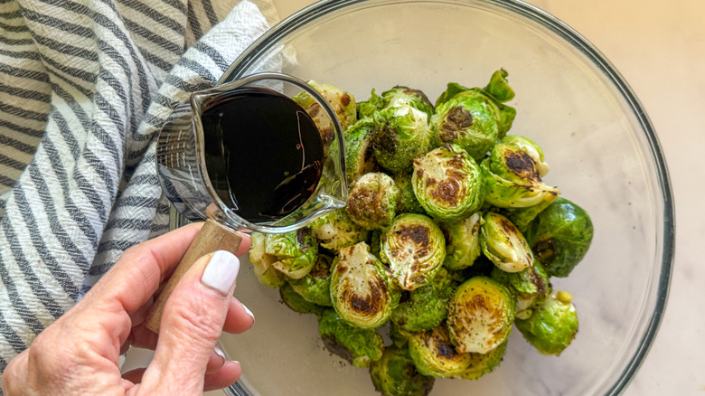 hand pouring glaze on sprouts