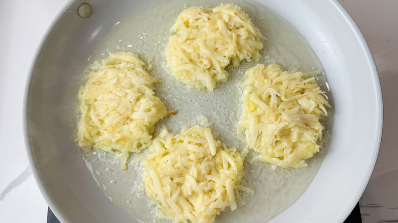 Latkes portioned into skillet