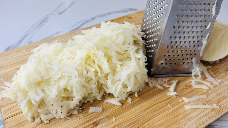 Grating potatoes on cutting board