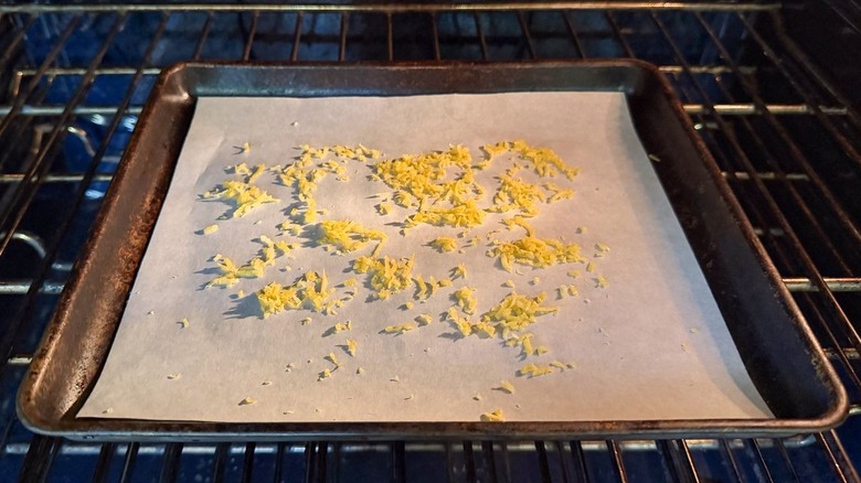 Lemon zest on parchment-lined baking sheet in oven