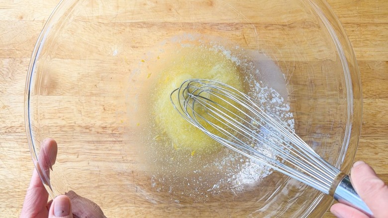 Whisking lemon butter glaze in large glass bowl