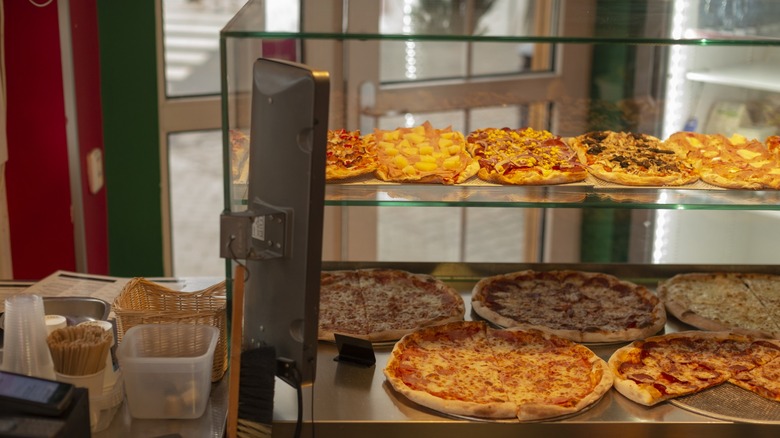 A pepperoni and cheese pizza in a to-go box from Crosby's gas station