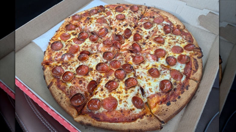 A pepperoni and cheese pizza in a to-go box from Crosby's gas station