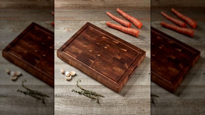 17-inch acacia cutting board with carrots, garlic, and herbs on the side
