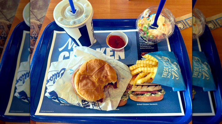 A kids menu tray at Culver's in the restaurant with a burger, fries, drink, and custard.