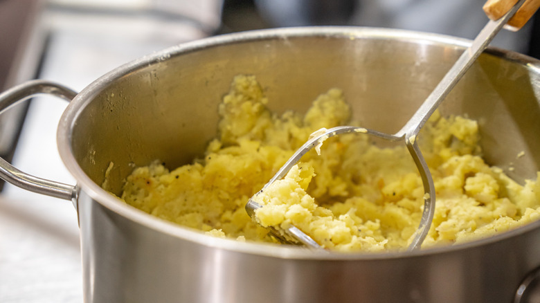 Close-up of a large pot of mashed potatoes being prepared in a restaurant kitchen