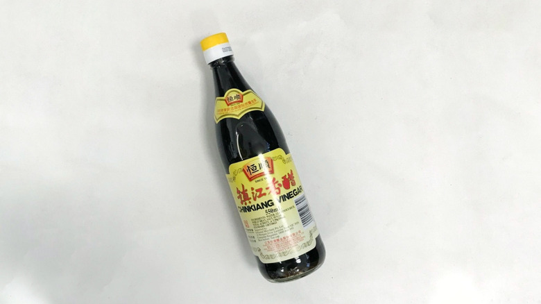 A bottle of Chinkiang black vinegar on a white background