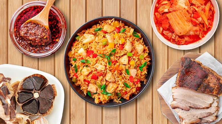 fried rice in the center surrounded by chili crisp, kimchi, and pork belly