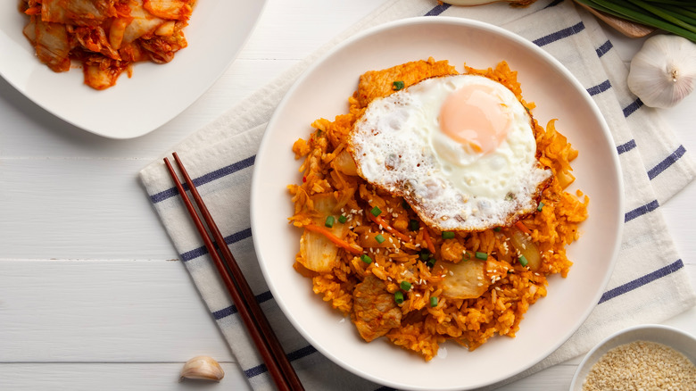 Kimchi fried rice topped with a fried egg, a bowl of kimchi off to the side